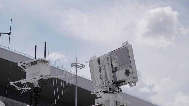 High-tech communication devices are displayed prominently in an outdoor setting, highlighting innovation and engineering under a bright sky with scattered clouds. photo