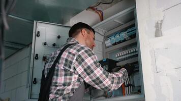 Electrician working on electrical panel installing a new device video