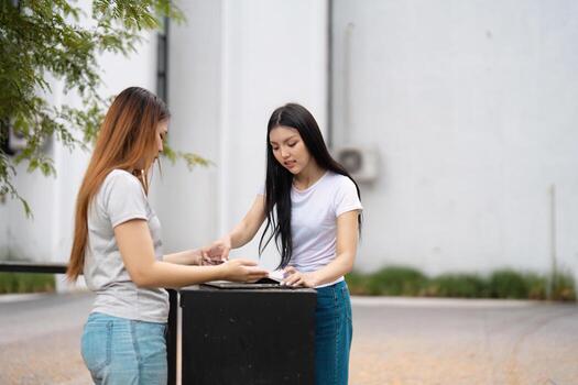 Diverse university students collaborating on a project at an outdoor table, sharing ideas and resources on campus. photo