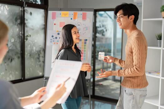UX UI designer presenting ideas to a client with visuals in a bright office. photo