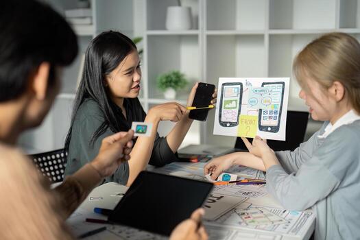 Creative UX UI Design Team Brainstorming Session with Digital Devices and Wireframes in Modern Office Environment photo