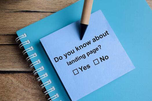 Do you know about landing page write on sticky notes isolated on Wooden Table. A person is answering question concept photo