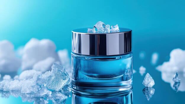 A glass jar filled with a translucent blue cream sits on a reflective surface surrounded by sparkling ice crystals. The bright blue background enhances the cooling effect photo