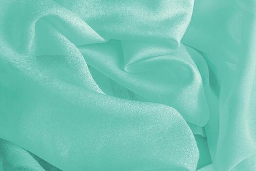Beautiful silk fabric texture background in delicate turquoise color. soft waves of fabric. copy space. Abstract holiday background for design. layout photo