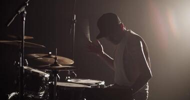 homem colocando em fone de ouvido e jogando batida em bateria video