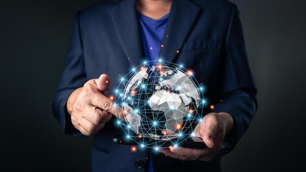 A man in a suit interacts with a glowing, digital globe above a smartphone, representing global business, networking, and connection through innovative technology and communication systems. photo