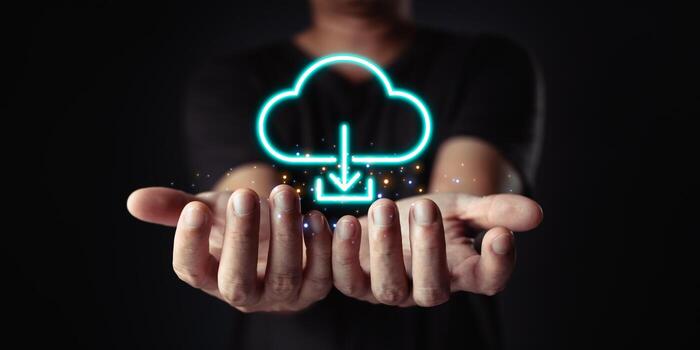 Data at your fingertips. Cloud computing is visualized with a glowing download icon above cupped hands, representing easy access and connectivity. photo