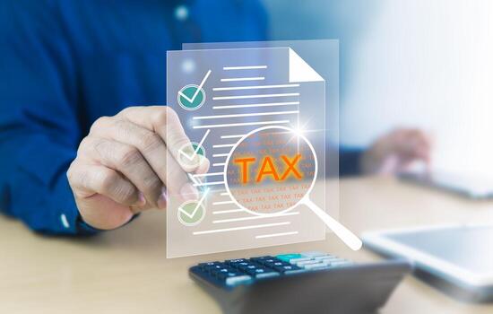 Taxes, Annual Income Tax Forms Online and Calculated with Calculator on Desk. Businessman Analyzes to Make List on Digital Paper by Different Sections with Check Marks in the Given Box. photo