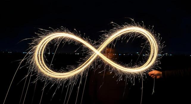 Sparkler Light Drawing Creating Infinite Loop at Night with Dark Sky Background photo