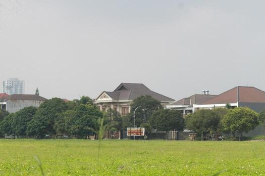 a field with a grassy area and a building in the background photo
