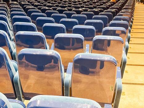 Rows of empty auditorium seats with glossy backs. Event preparation, public gathering, and modern infrastructure in an indoor conference or performance venue. photo