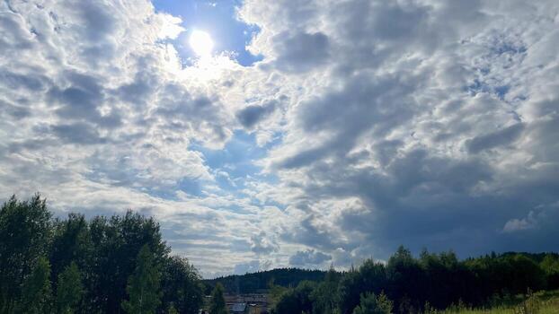 A field with trees and a sky filled with clouds photo