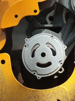 A close up of a machine part with a smiling face on it. The face is made up of two circles, one on each side of the machine part photo