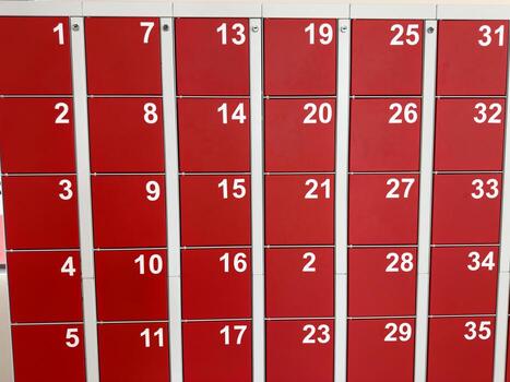 Red lockers with white numbers arranged in rows. A clear and simple design for personal storage, with numbered slots for easy identification photo