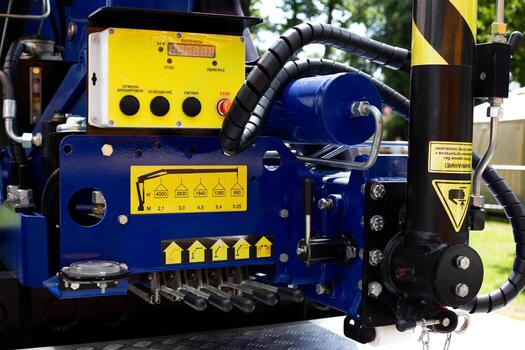 Close up of control panel and hydraulic system of manipulator used for cargo handling. The image highlights technical details and operational buttons essential for lifting and moving heavy loads photo