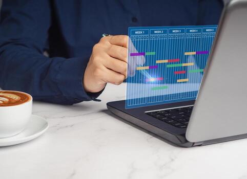 Project manager working on a laptop and updating tasks and milestones progress planning. photo