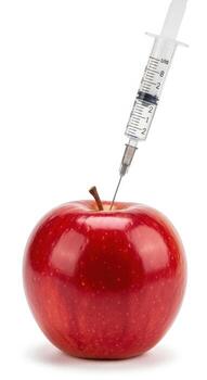 Red apple with syringe needle inserted into stem on white background injection photo