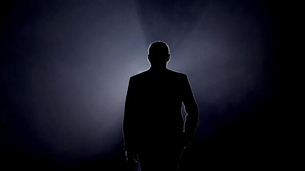 Silhouette of a man on stage illuminated by stage lights photo