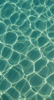 Sunlight patterns on the surface of clear blue water photo
