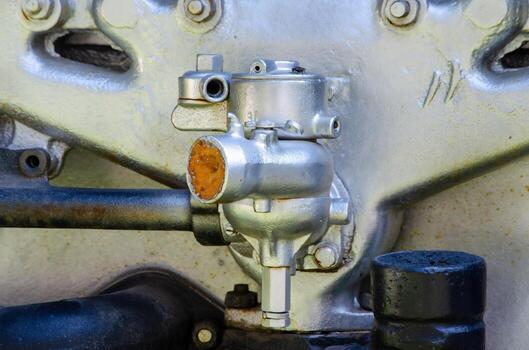 A close up of a car engine with a bolt on it. The bolt is rusty and the engine is old photo