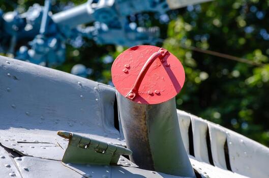 A red cap on a pipe. The cap is red and has a silver base photo