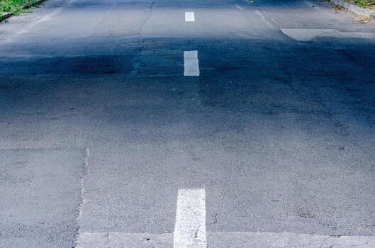A road with a white line down the middle. The road is empty photo