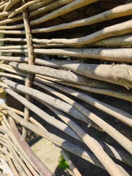 A close up of a wooden structure with many thin, long wooden sticks. The sticks are arranged in a way that creates a pattern, and the overall mood of the image is one of simplicity and natural beauty photo