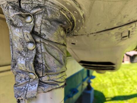 A silver object with a silver button on it. The button is on the left side of the object photo