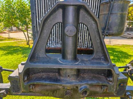 The front of a vehicle has a black frame and a black radiator. The radiator is attached to the frame with bolts photo