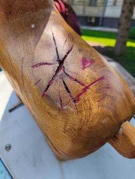 A wooden object with a large hole in it and a red stain. The hole is in the shape of a star photo