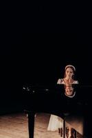 reflexión de elegancia a el piano y pianista en destacar un pianista en un blanco vestir graciosamente se sienta a un grandioso piano, su sereno expresión reflejado en el lustroso superficie de el instrumento. el foto