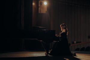 concierto pianista mujer en un teatro destacar en negro vestir foto