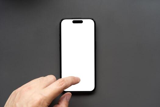 Hand Touching Smartphone with Blank White Screen. finger touching the display, isolated against a dark background. Ideal for app mockups, UI presentations, and technology concepts. photo
