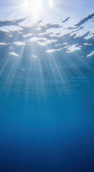Sunlight beams through the ocean surface creating beautiful patterns photo