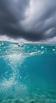 Underwater view of bubbles rising towards a stormy sky photo