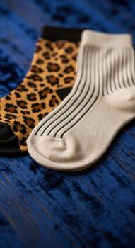 Two Pairs of Socks Leopard and Striped Pattern on Blue Fabric photo
