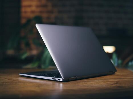 Sleek silver laptop positioned on a wooden table with a soft focus background, creating a modern atmosphere. photo