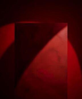 Dramatic red stage with spotlight and shadows creating depth photo