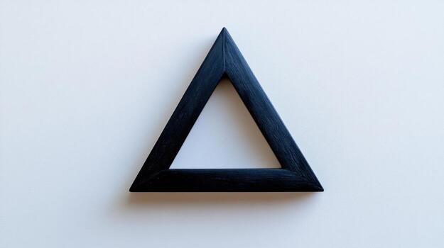 A black triangle shaped object on a white surface photo