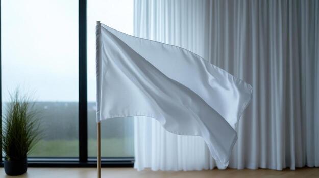 A white flag stands tall in a sleek indoor setting with large windows showcasing a grey, overcast sky. The environment feels calm, enhancing the flag's significance photo