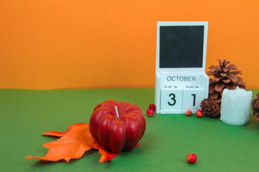 The pumpkin stands on an orange maple leaf, with a calendar showing the Halloween date on the back. photo
