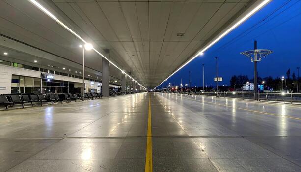 A long empty airport terminal with benches and lights photo