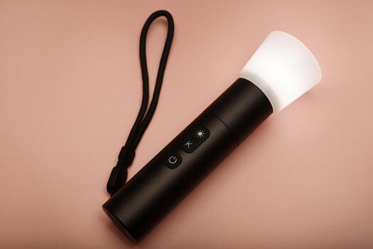 A tactical LED flashlight. Compact and powerful light source for outdoor use. Flashlight placed on a dark textured background. photo