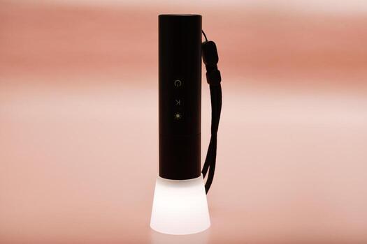 USB rechargeable flashlight. Sleek design for modern use. Positioned on a reflective black surface. photo