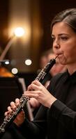 mujer jugando el oboe en un orquesta con un negro camisa y enfocado expresión en su cara durante actuación foto