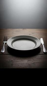 un sencillo sitio ajuste presentando un plato tenedor y cuchillo en un rústico de madera mesa superficie en oscuro Encendiendo foto