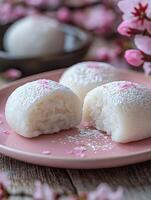 Delicate Mochi Bites with Pink Blossom Accents on a Rustic Surface. photo