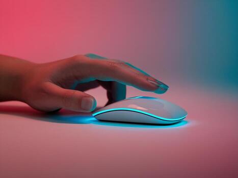 A hand gently touches a sleek, illuminated computer mouse against a gradient background. photo