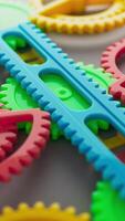 Perfectly looped 3D animation of bright plastic gears and racks in red, yellow, blue, and green, moving in unison with precision, producing a colorful, dynamic, and endlessly repeating visual effect. video