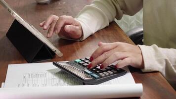 donna utilizzando un in linea bancario applicazione su un' computer per calcolare mensile costi e Risolvere utilità pagamenti. video